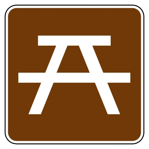 Brown square sign with a white picnic-table symbol and white border.