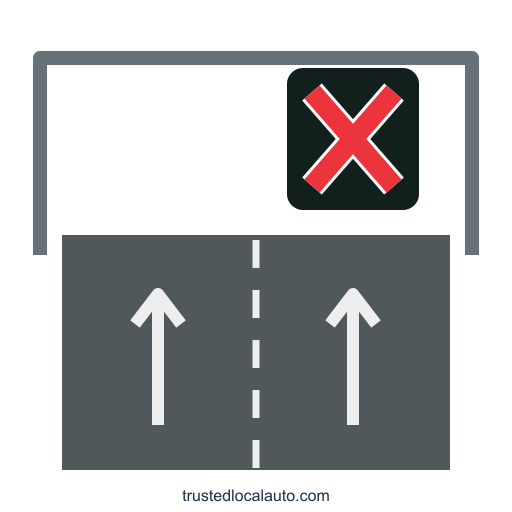 A red X in an overhead black display is centered over the right of two forward travel lanes. A dashed white line separates the lanes.