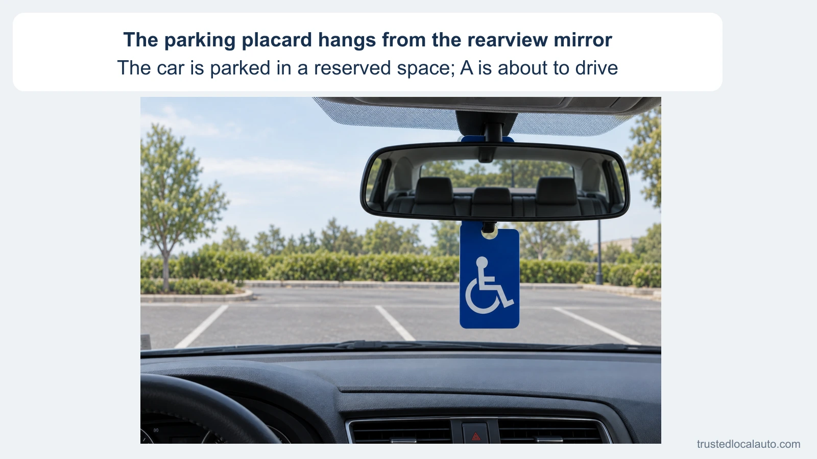 From a parked car’s driver area, a blue disability parking placard hangs below the rearview mirror and blocks part of the windshield view. The card states that the car is in a reserved space and the driver is about to leave.