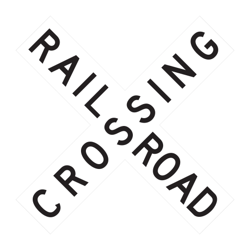 A white X-shaped sign carries the black words RAILROAD CROSSING, without lights or gates.