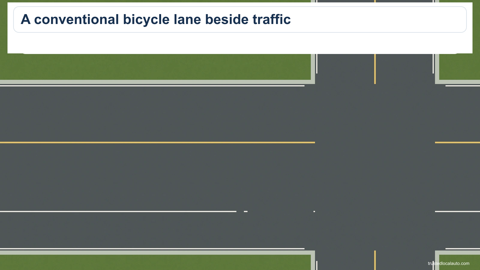 An empty roadway and adjacent bicycle lane meet a side road. White dashed paint separates the bicycle lane from the traffic lane.