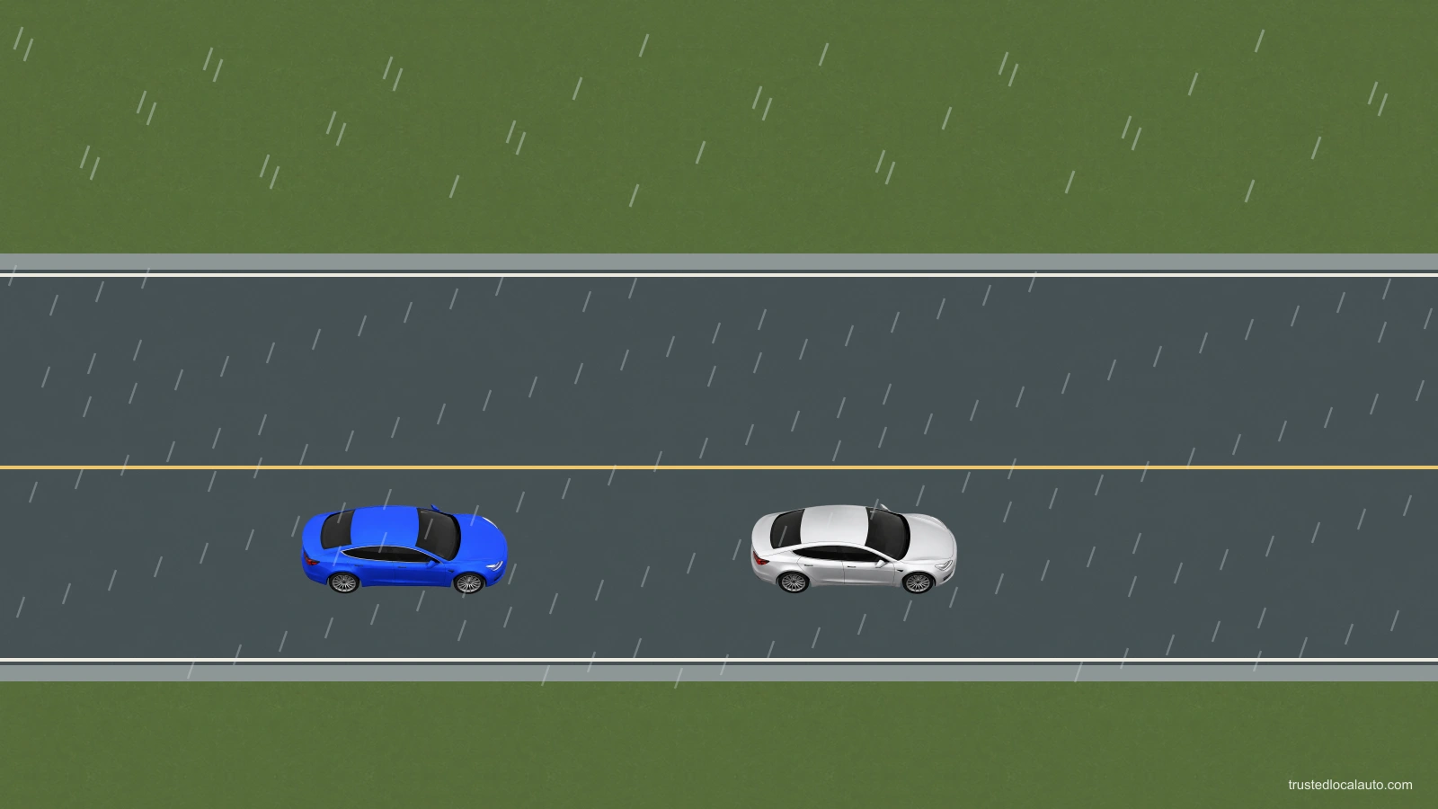 Blue and silver cars travel along a wet two-way road in rain, with reduced visibility.
