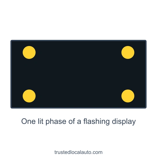 A black rectangular work-zone board shows four yellow lights, one near each corner, during a lit phase of its flashing display. No directional arrow is shown.